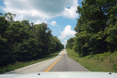 Road amidst trees against sky