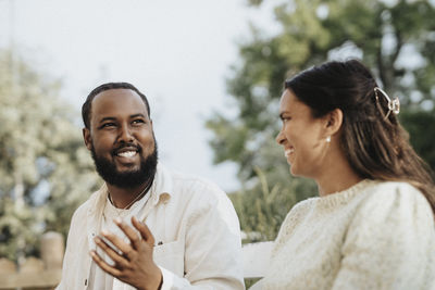 Smiling young man talking to female friend during dinner party