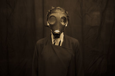 Portrait of young woman wearing gas mask