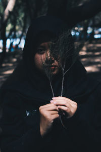 Close-up portrait of woman holding plant