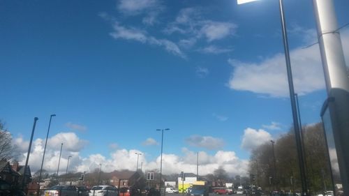 Cars on road against cloudy sky