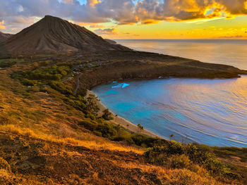 Scenic view of sea against cloudy sky during sunset