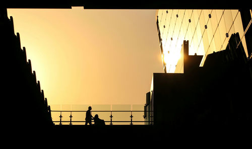 Silhouette buildings against sky during sunset