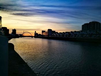 View of city at waterfront during sunset