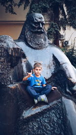 Portrait of boy sitting on rock