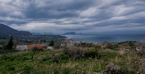 Houses by sea against sky