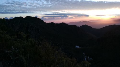 Scenic view of silhouette mountains against sky at sunset