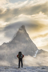 Rear view of man on mountain against sky