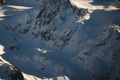 Aerial view of aircraft flying by snowcapped mountain at garibaldi park