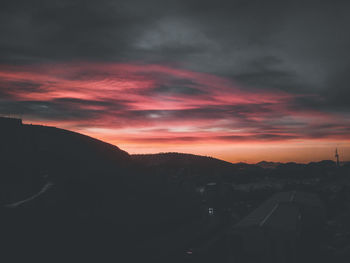 Scenic view of silhouette mountains against dramatic sky