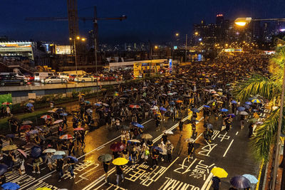 High angle view of people on city street at night during rainy season