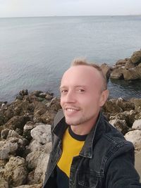 Portrait of man on rock against sea