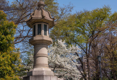 Low angle view of trees and tower against sky