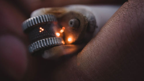 Close-up of hand holding burning candle