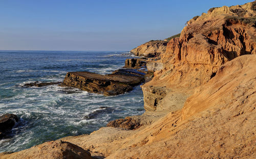 Rock formation on beach against sky