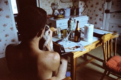 Rear view of woman sitting on table