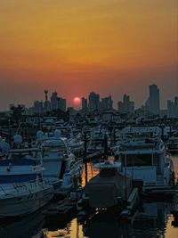 High angle view over marina docks as sun sets between the high rise buildings of kuwait city 