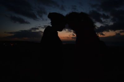 Silhouette couple against sky during sunset