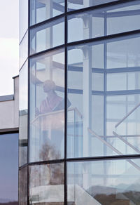 Thoughtful businesswoman standing in office seen through glass