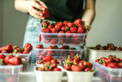 Midsection of woman holding strawberries