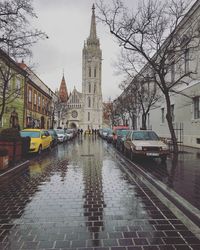 Canal amidst buildings in city during rainy season