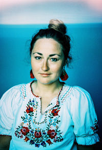 Portrait of smiling woman standing against wall