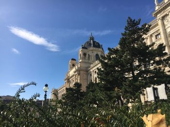 Low angle view of trees and building against sky