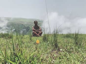 Woman sitting on mountain peak