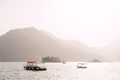 Boat in sea against mountain