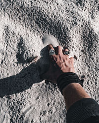 High angle view of human hand holding sand