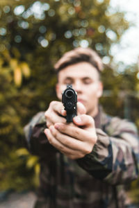Man shooting gun while standing outdoors