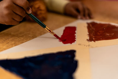 Midsection of woman painting on table