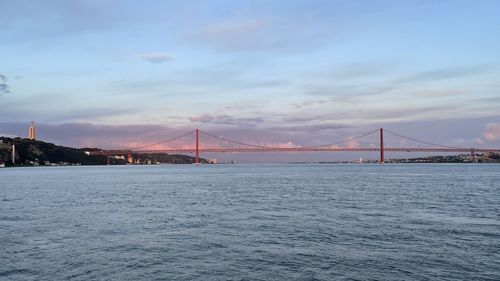 View of suspension bridge against cloudy sky