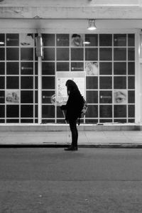 Full length rear view of woman walking in building