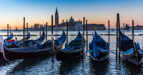 Boats moored at canal against sky