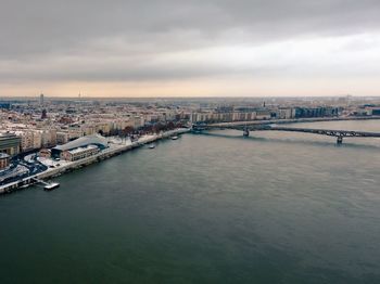 Bridge over river in city against sky