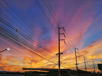 Low angle view of silhouette electricity pylon against sky during sunset