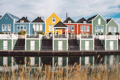 Houses by river against buildings in city