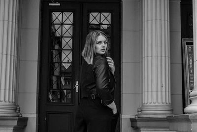 Portrait of woman standing against window