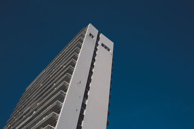 Low angle view of modern building against clear blue sky