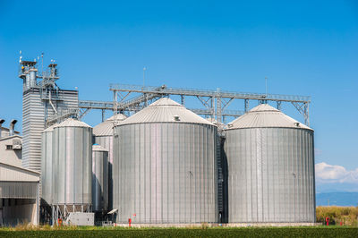 Silo on field against blue sky