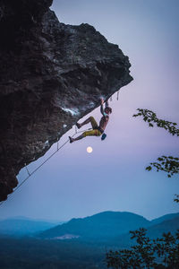 Man climbing overhanging sport climbing route in new hampshire