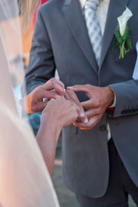 Midsection of couple holding hands