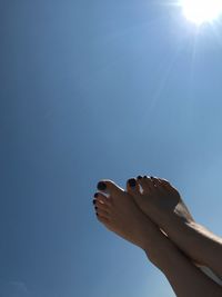 Low angle view of hand against blue sky