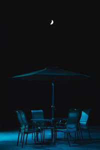 Empty chairs and tables at night