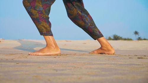 Low section of person standing on beach