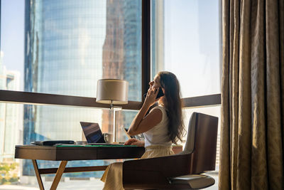 Low section of woman sitting on table at home