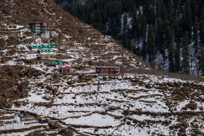Snow covered field by buildings