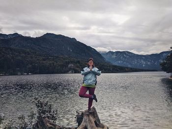Full length of man standing on lake against mountains