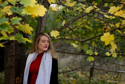 Portrait of a beautiful young woman standing in autumn